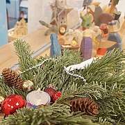 Nahaufnahme einer festlichen Dekoration mit Tannenzweigen und Christbaumschmuck.