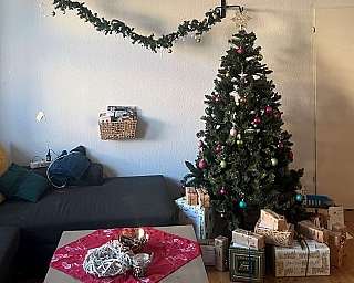 Ein festlich geschmückter Weihnachtsbaum mit Geschenken und Dekoration.